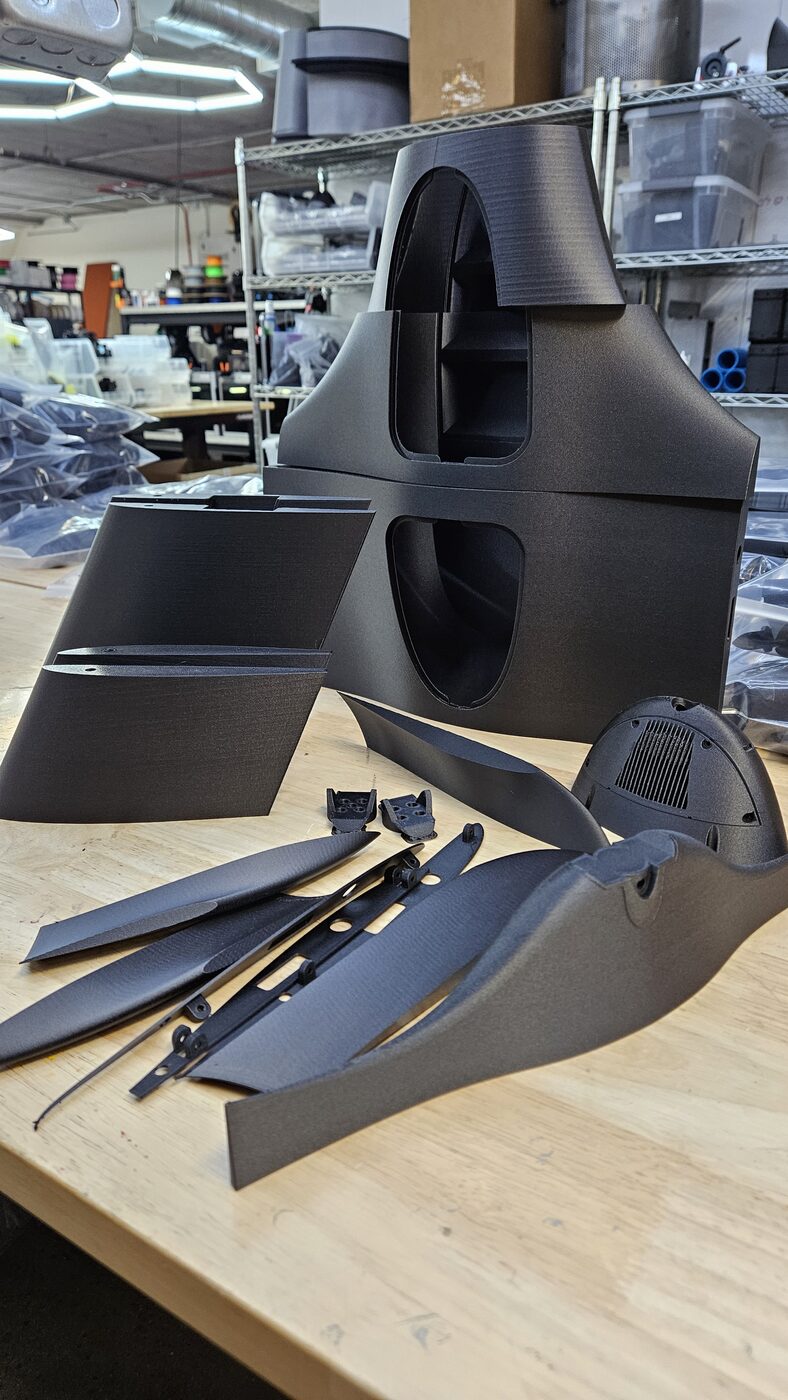 A complete custom drone frame kit laid out after manufacturing, including arms, plates, and props