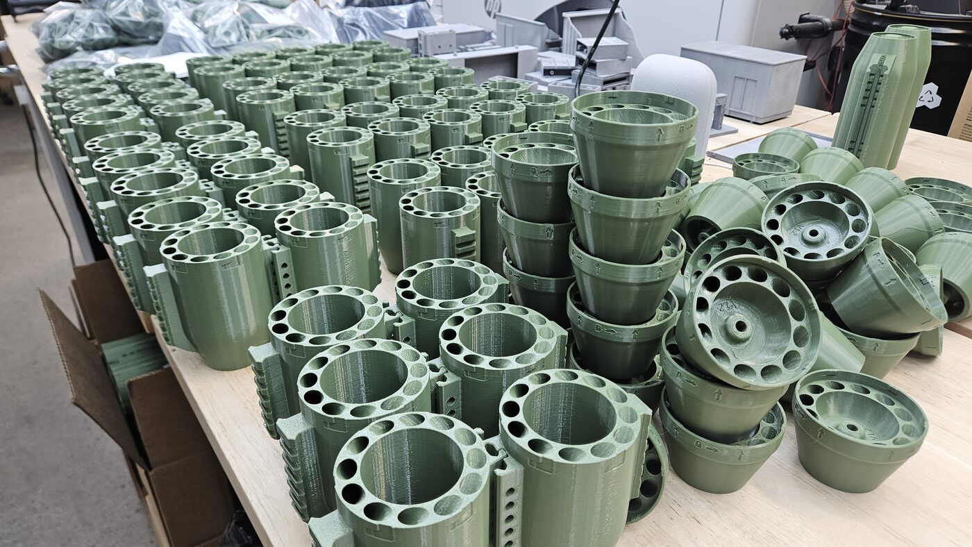 A large batch of freshly printed drone components staged for post-processing